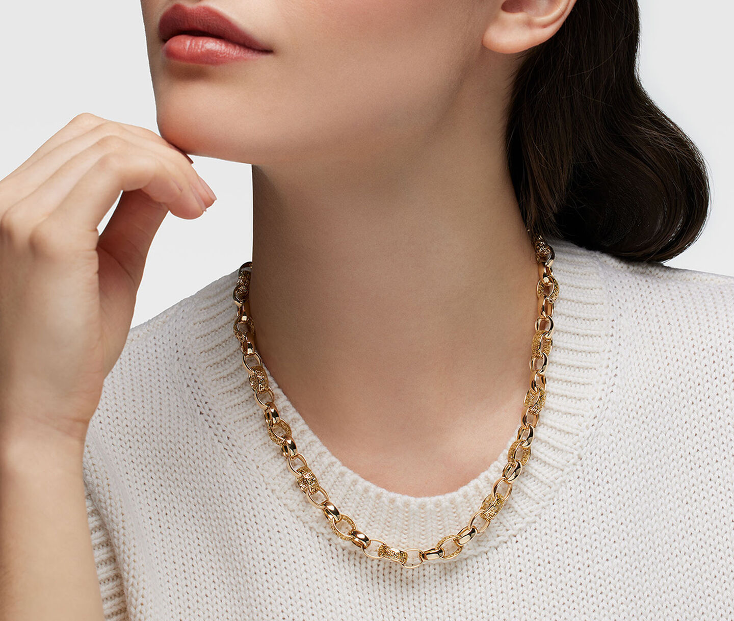 A woman wearing a Birks Muse gold chain necklace.